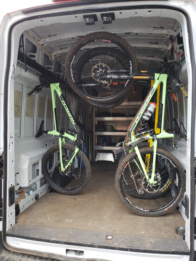 multiple bikes stored inside a van with wheels on. 
