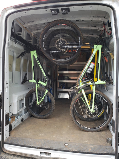 multiple bikes stored inside a van with wheels on. 